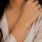Gold bracelet with 'Amanda' engraved on a person's wrist.