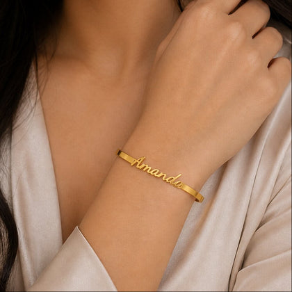 Gold bracelet with 'Amanda' engraved on a person's wrist.